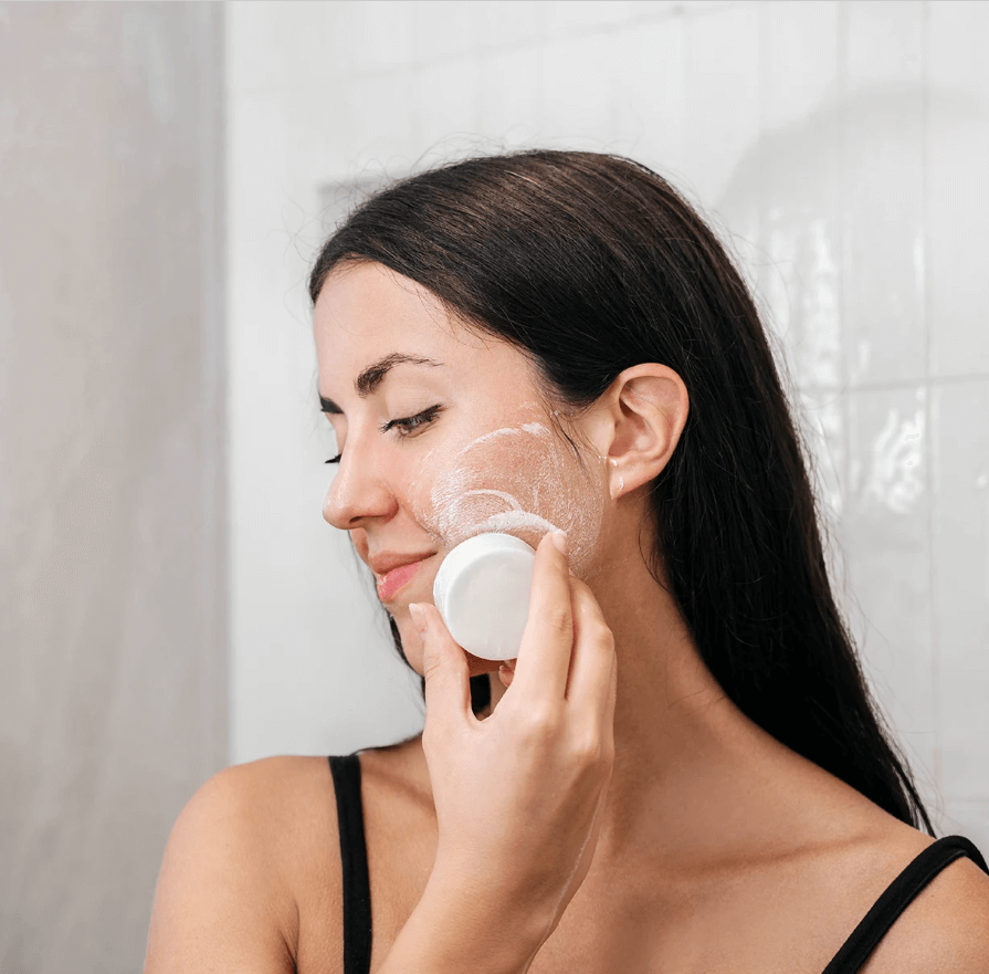 Woman using Solve Solid Facial Cleansing Bar for gentle and organic skincare routine.